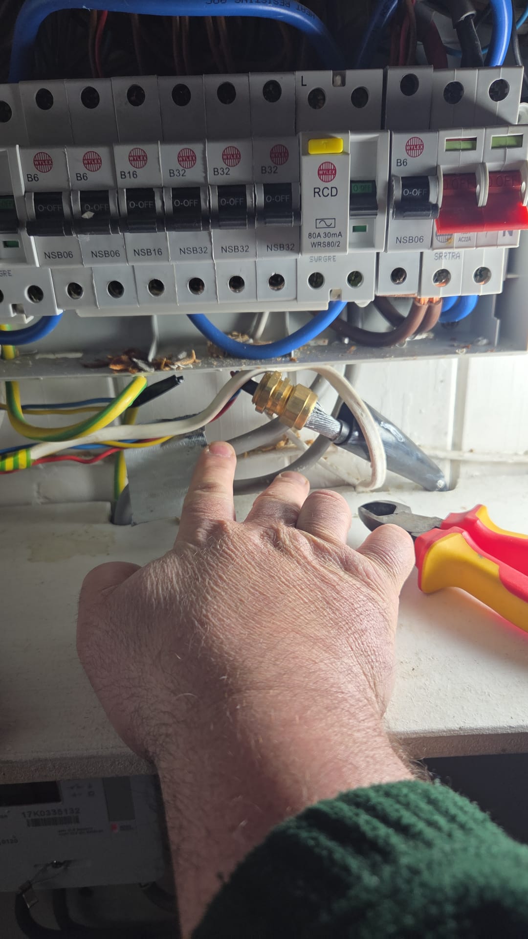 Failed EICR – exposed and unprotected wiring identified by electrician in Clapham Electrician in Clapham carrying out electrical testing and fault finding in a residential property.