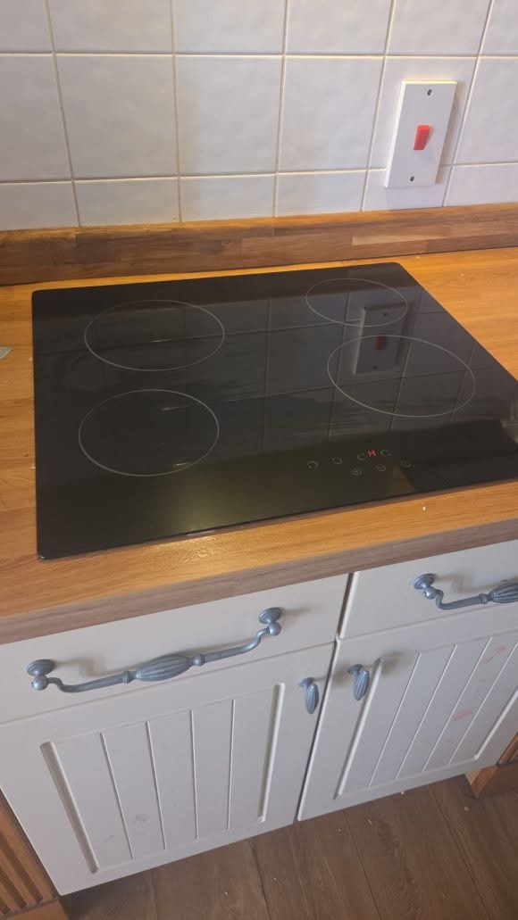 Electrician installing a new electric induction hob in Raynes Park by BuildSpark